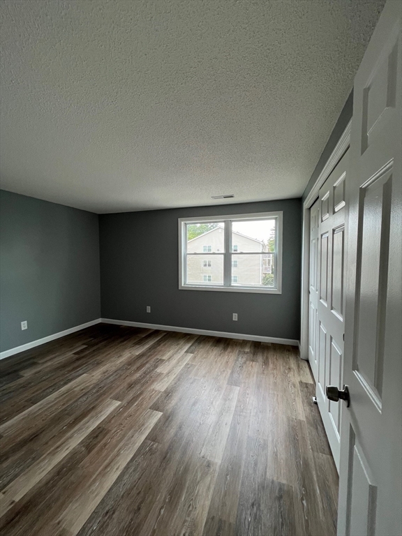 1475 Braley Road, Unit 17 New Bedford, MA 02745 - Photo 5 of 9 a view of an empty room with wooden floor and a window