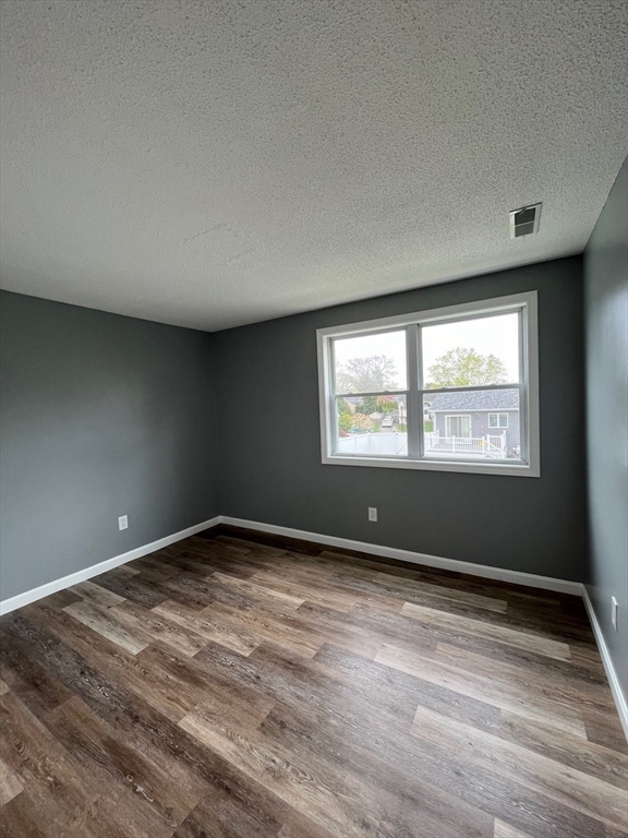 1475 Braley Road, Unit 17 New Bedford, MA 02745 - Photo 6 of 9 a view of an empty room with wooden floor and a window
