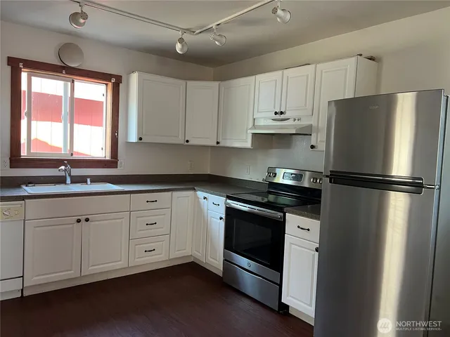a kitchen with stainless steel appliances granite countertop a refrigerator and a stove top oven