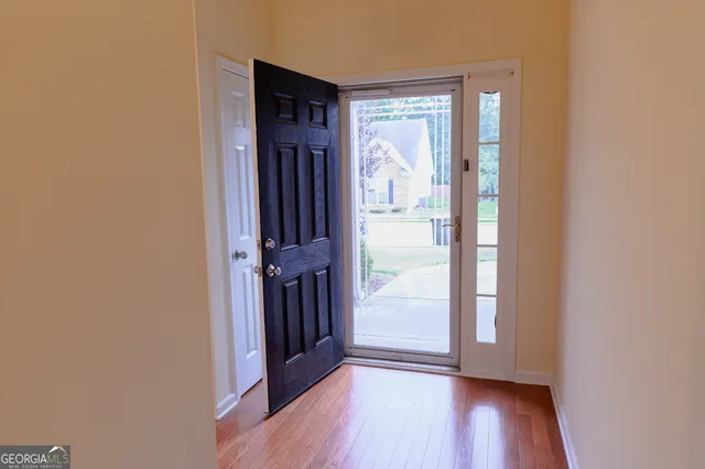 a view of a bedroom with a bed and wooden floor