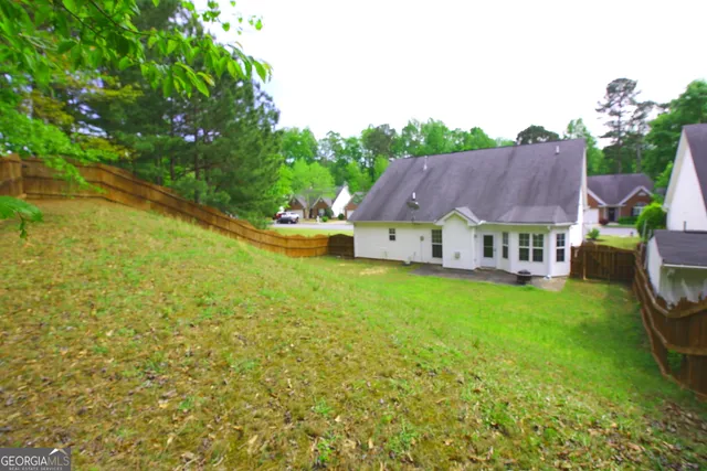 a view of swimming pool with lawn chairs and large trees
