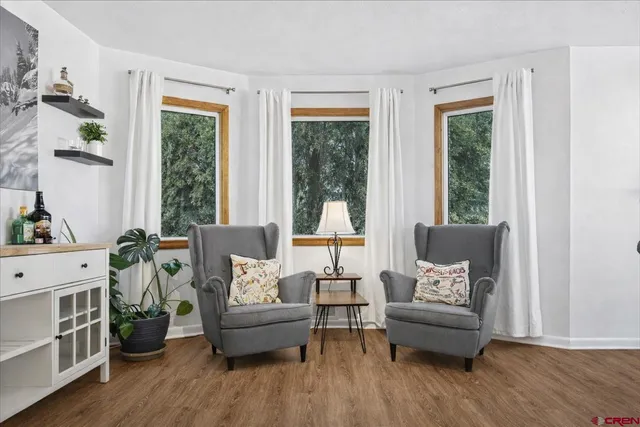 a view of a hallway with wooden floor and a potted plant