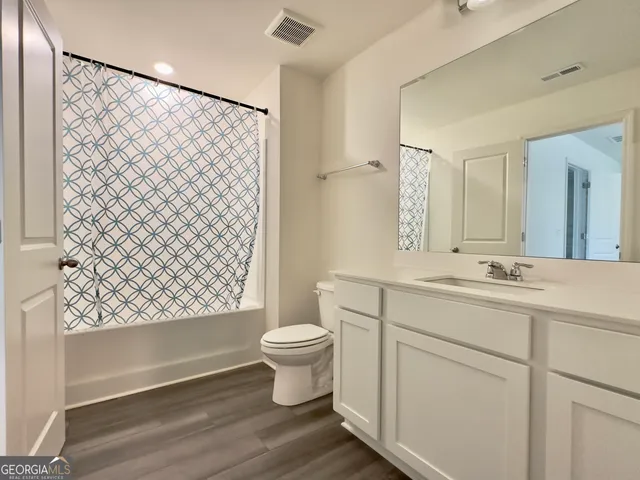 a bathroom with a sink toilet a mirror and shower