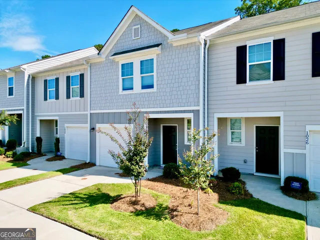 a front view of a house with yard garage and outdoor seating