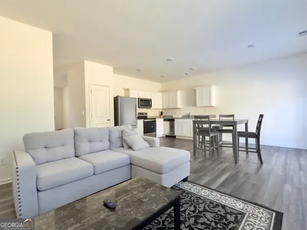 a living room with furniture wooden floor and a table