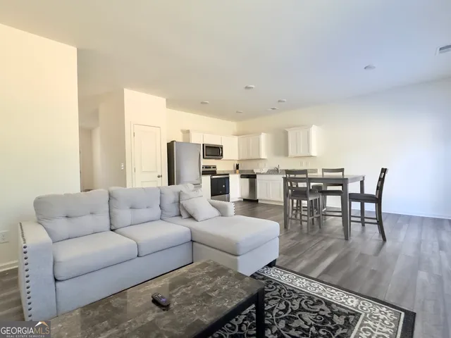 a living room with furniture wooden floor and a table