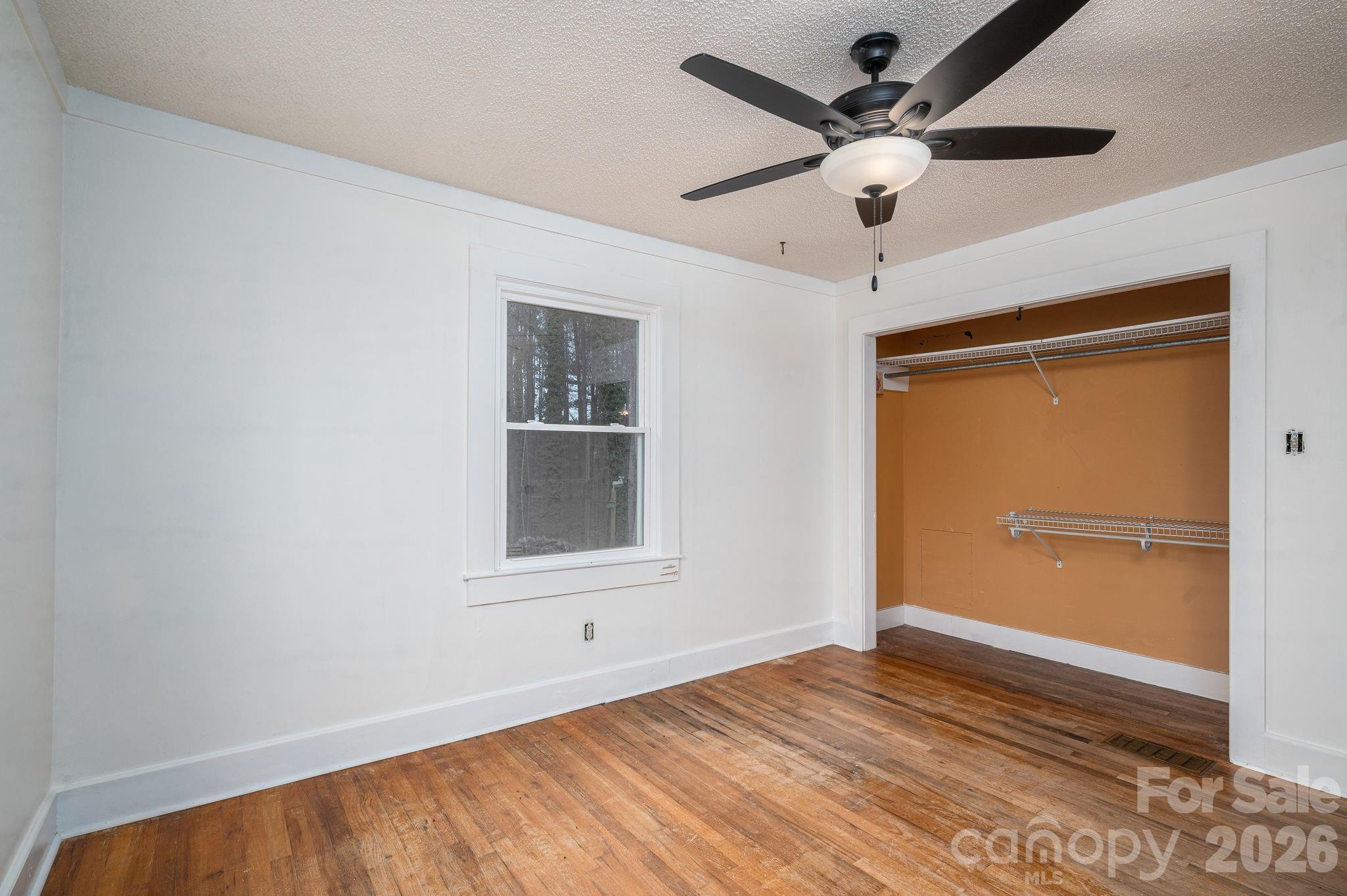 2033 Puetts Chapel Road Bessemer City, NC 28016 - Photo 14 of 38 a view of empty room with wooden floor and ceiling fan