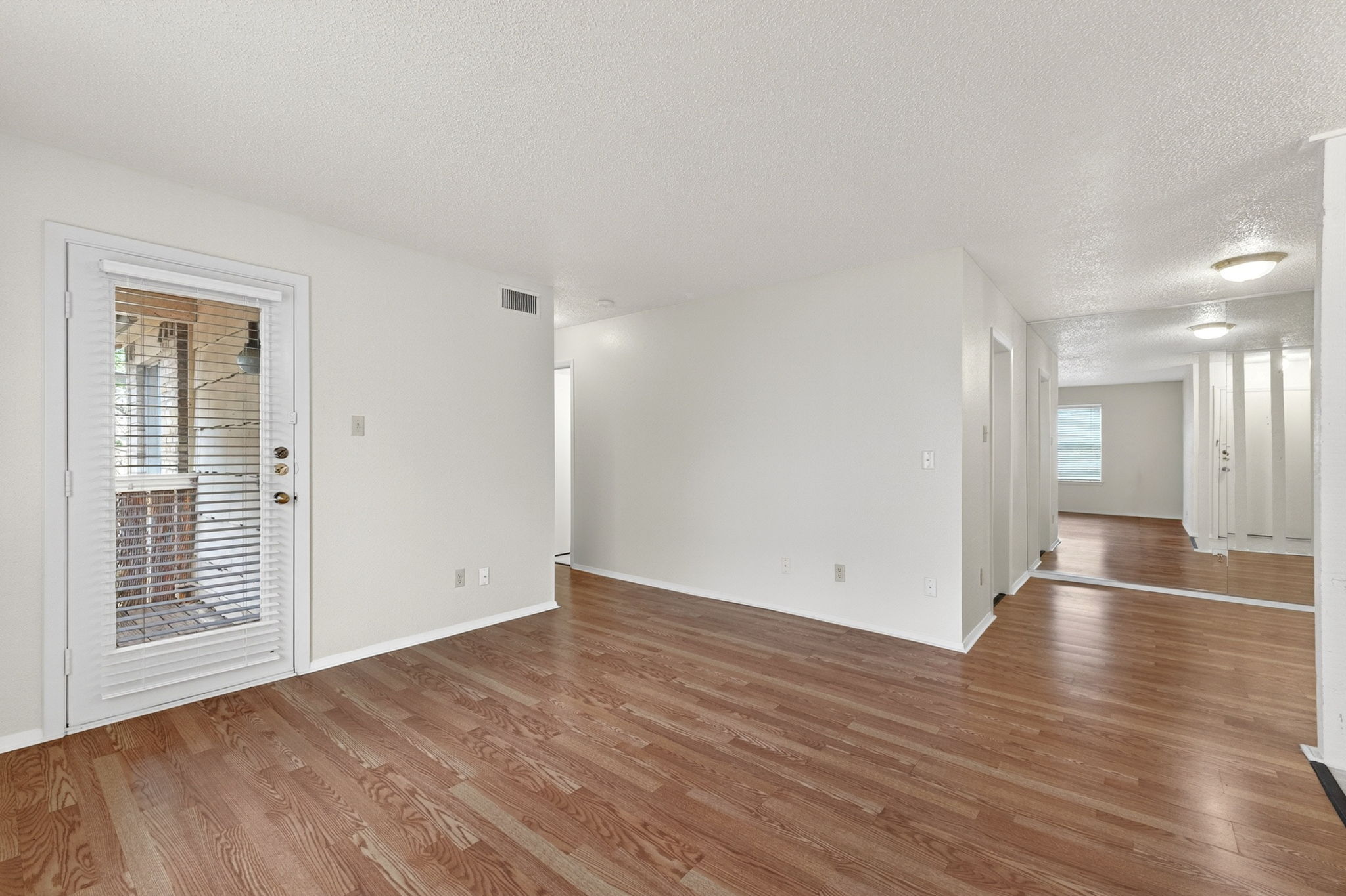8210 Bent Tree Road, Unit 256 Austin, TX 78759 - Photo 5 of 29 a view of an empty room with wooden floor and a window