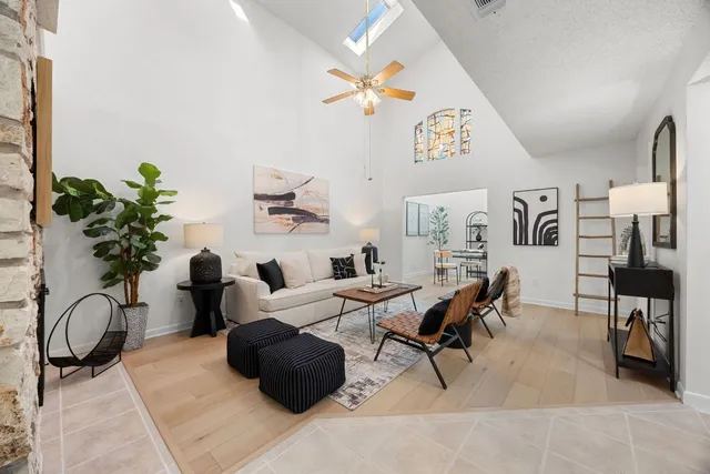 a living room with furniture a chandelier and a potted plant