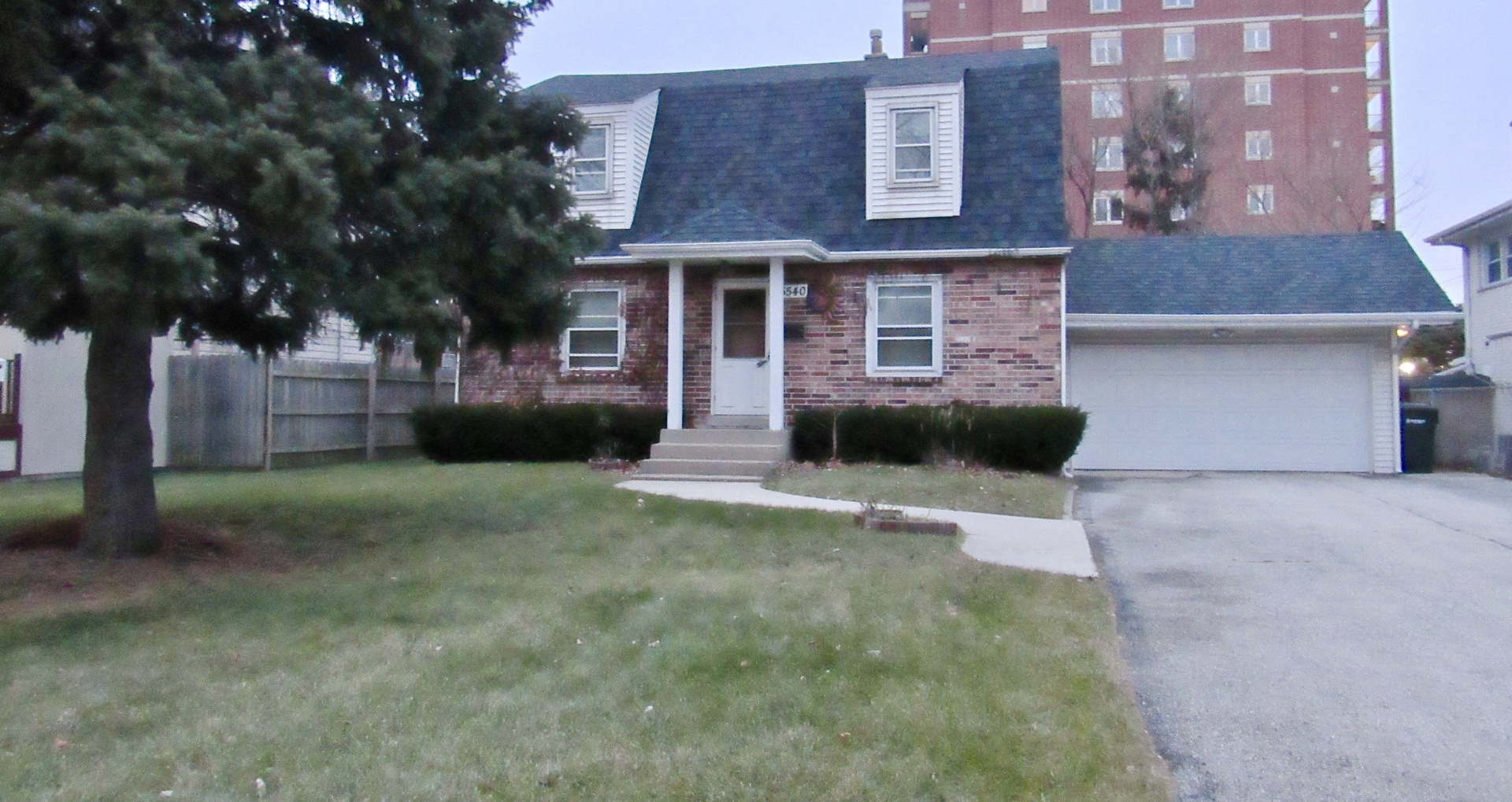 a front view of a house with a yard and a garage
