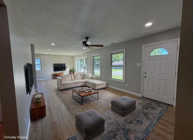 a living room with furniture and a wooden floor