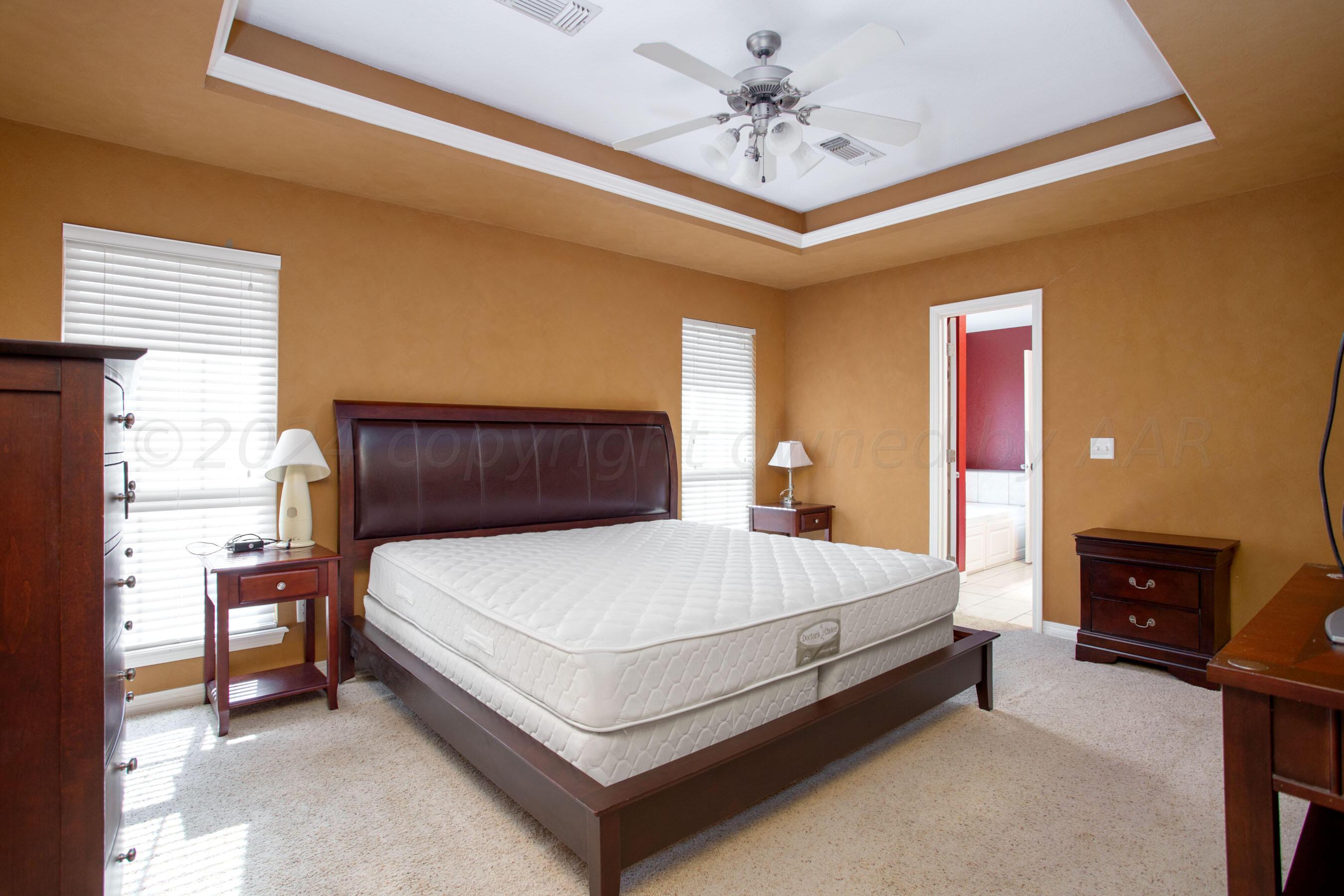 6501 Academy Drive Amarillo, TX 79119 - Photo 11 of 22 a bed sitting in a spacious bedroom next to a window