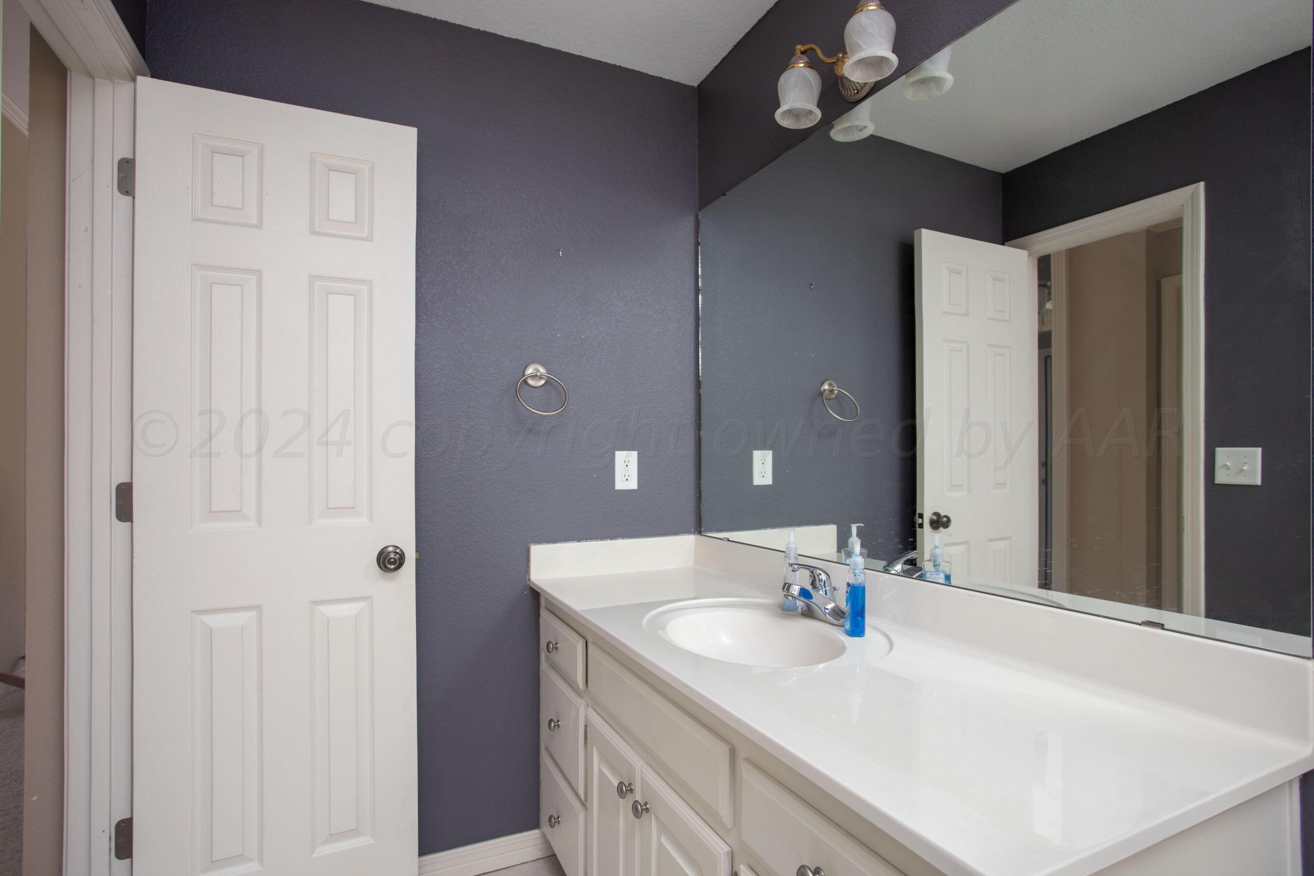 6501 Academy Drive Amarillo, TX 79119 - Photo 17 of 22 a bathroom with a sink vanity and a mirror
