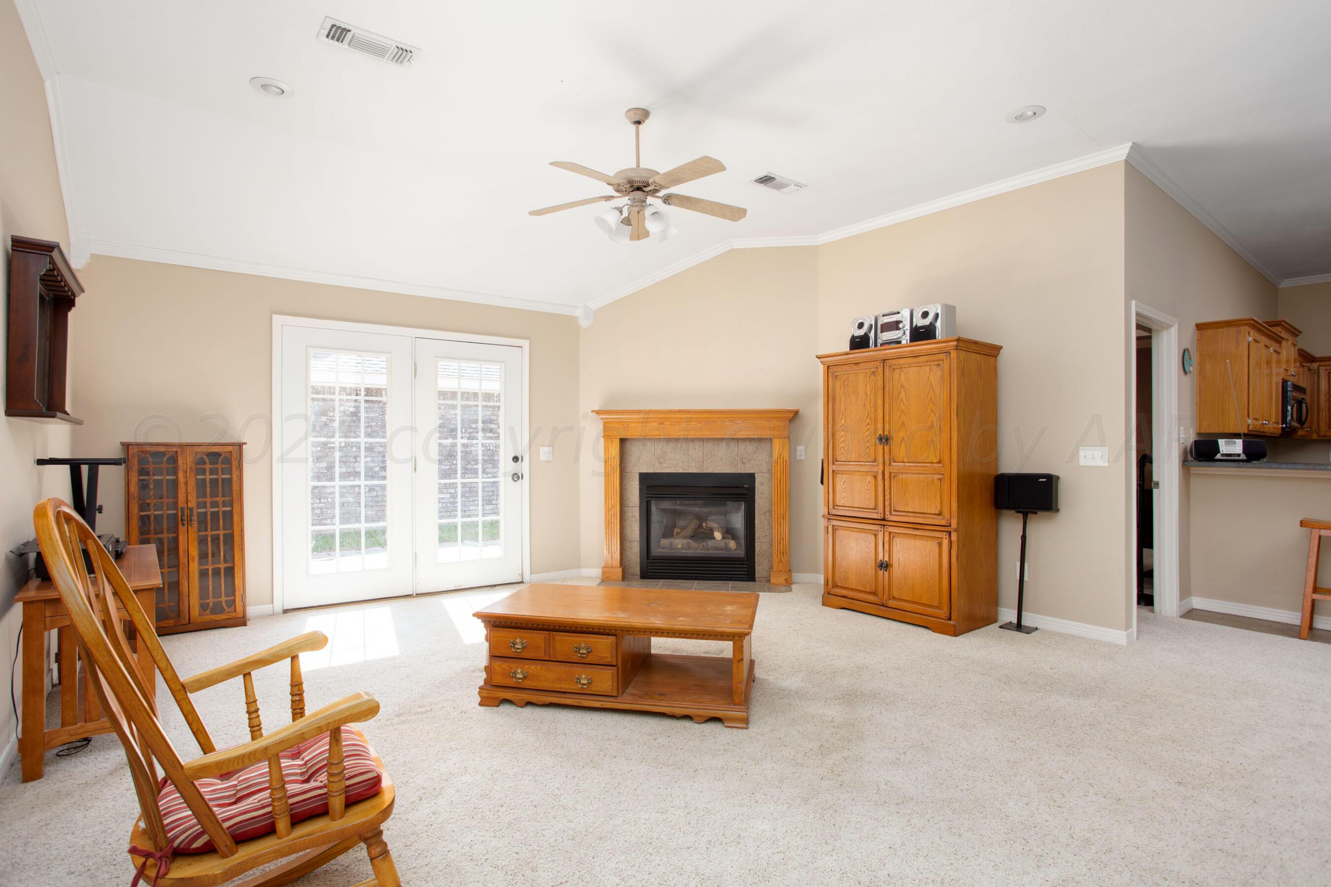 6501 Academy Drive Amarillo, TX 79119 - Photo 4 of 22 a living room with furniture a fireplace and a flat screen tv