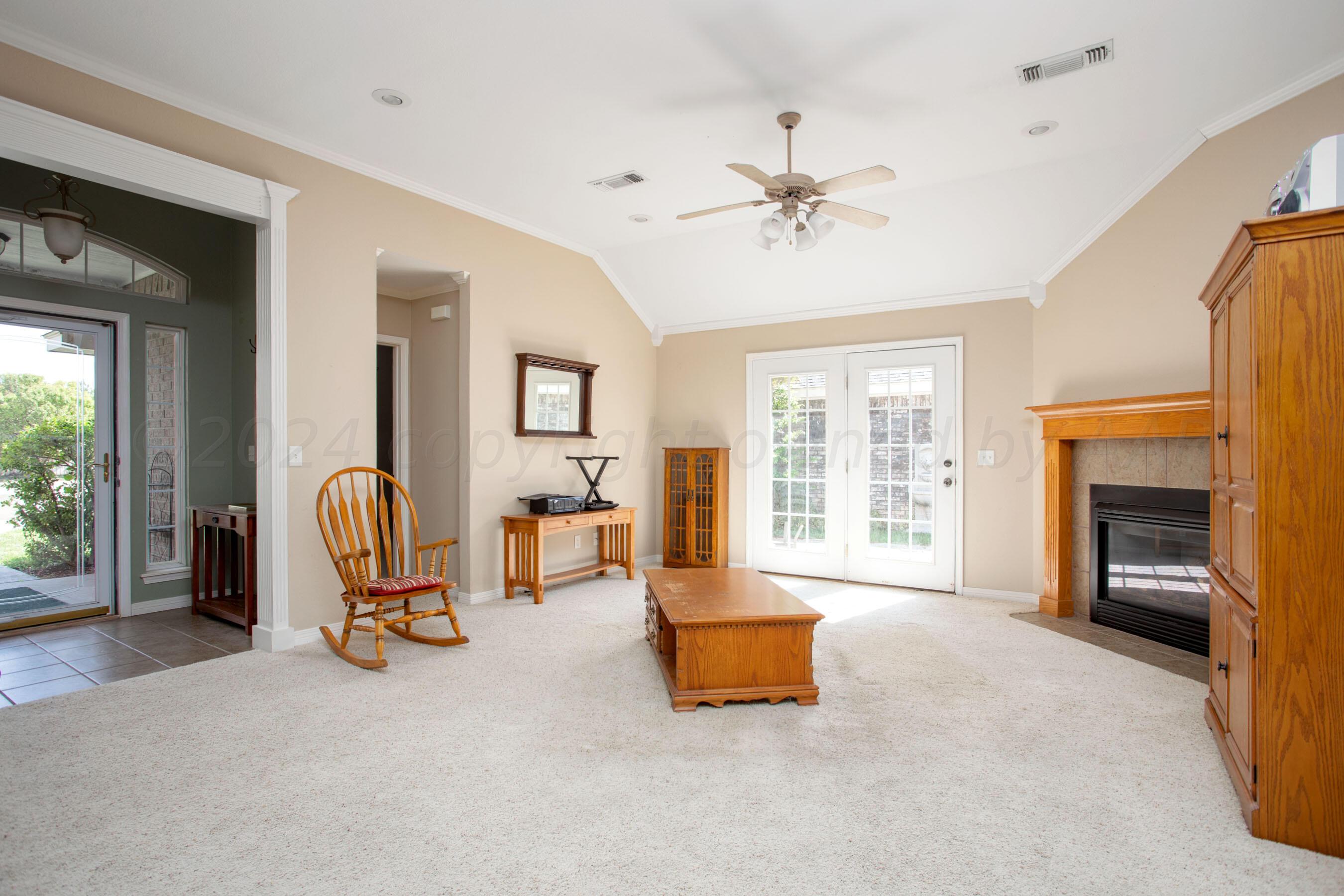 6501 Academy Drive Amarillo, TX 79119 - Photo 5 of 22 a living room with furniture a fireplace and large windows