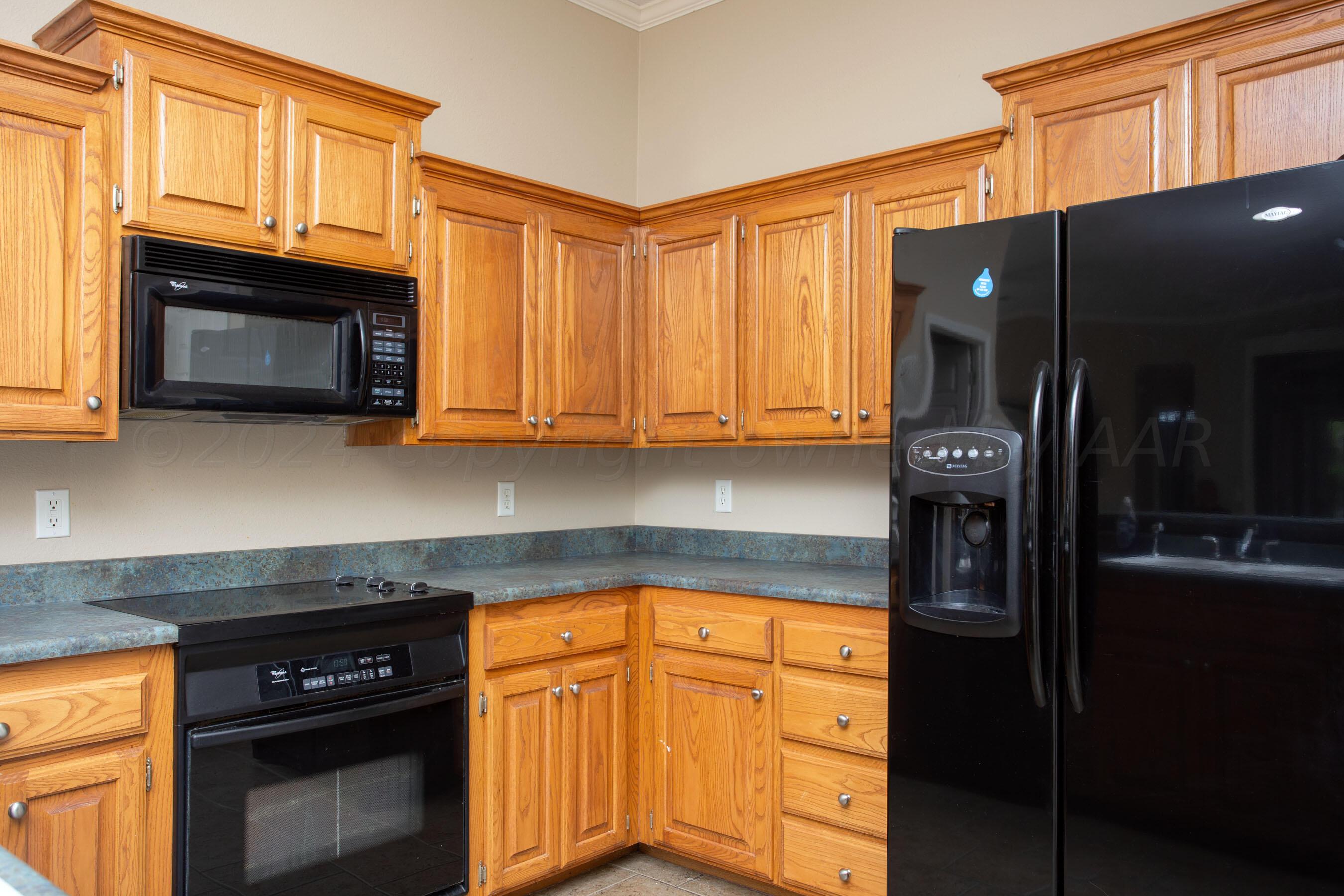 6501 Academy Drive Amarillo, TX 79119 - Photo 8 of 22 a kitchen with stainless steel appliances granite countertop a stove top oven microwave and cabinets