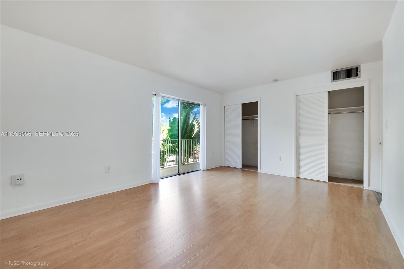 7403 Southwest 82nd Street, Unit 210N Miami, FL 33143 - Photo 9 of 14 an empty room with wooden floor and windows