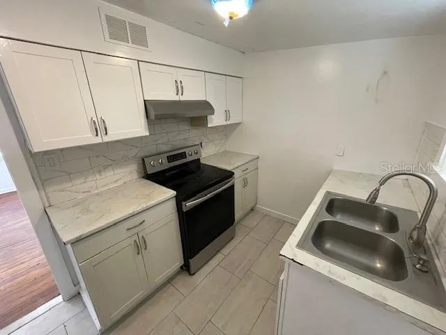 a kitchen that has a sink and a stove