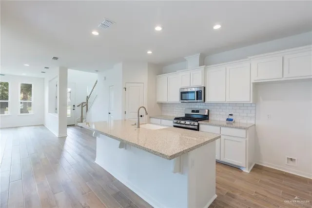 a kitchen with granite countertop a sink stove and refrigerator