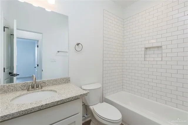 a bathroom with a granite countertop toilet a sink and bathtub