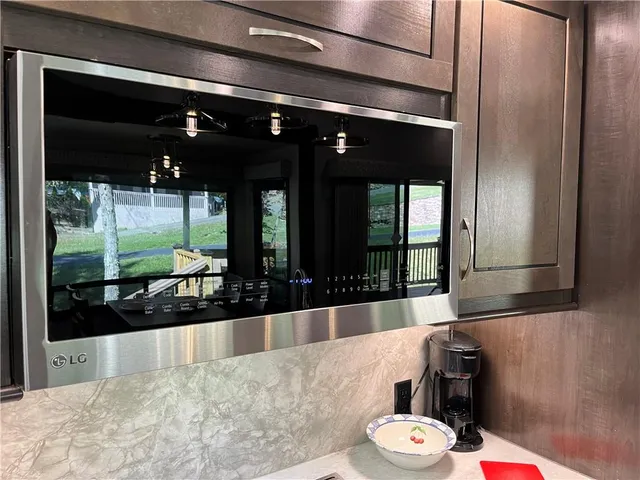 a room with stainless steel appliances kitchen island granite countertop a refrigerator and a stove