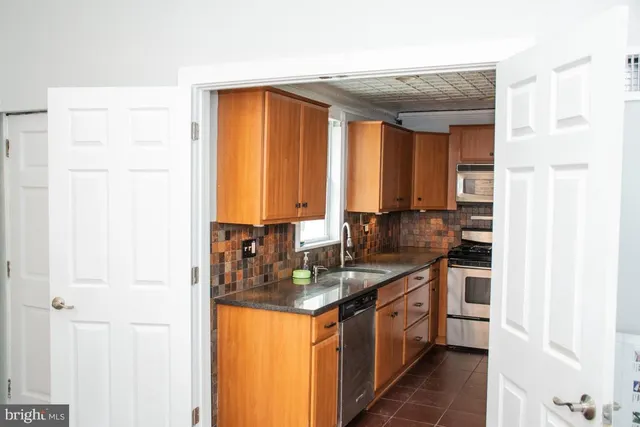 a kitchen with stainless steel appliances granite countertop a sink and a refrigerator