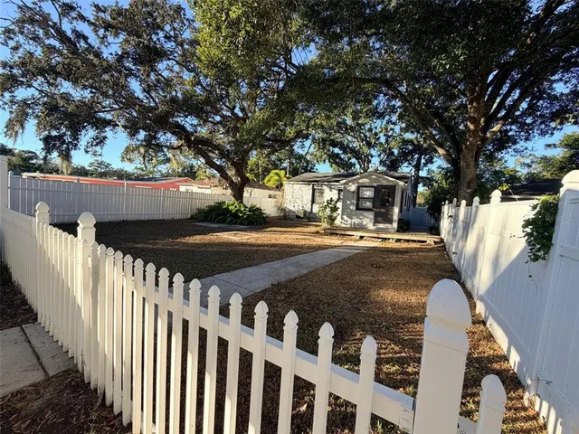 a view of a yard with wooden fence