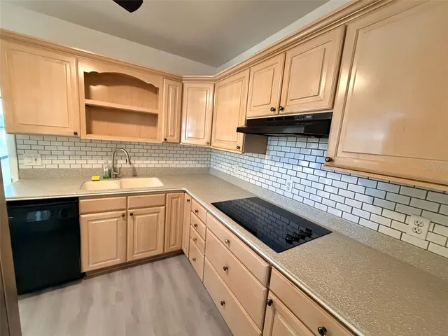 a kitchen with a sink a stove and cabinets