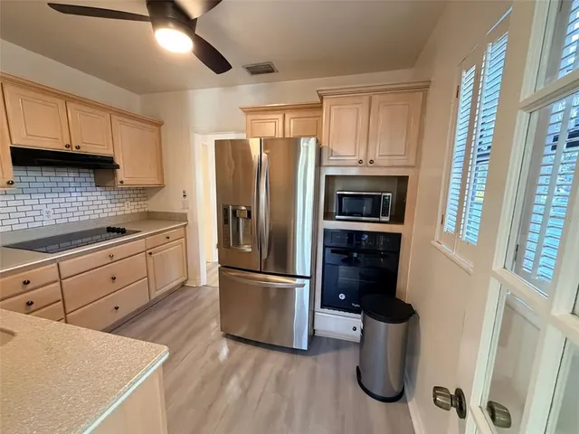 a kitchen with a refrigerator sink and cabinets