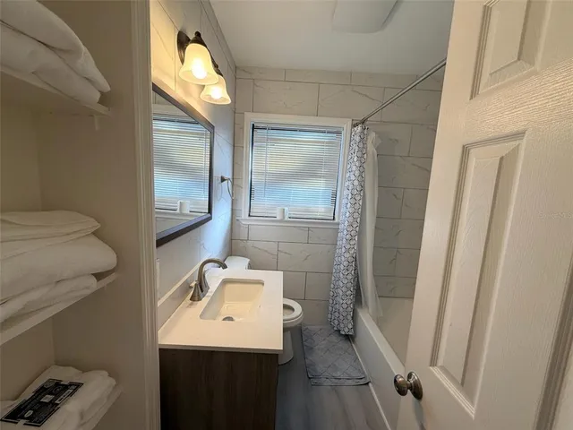 a bathroom with a sink and mirror with toilet