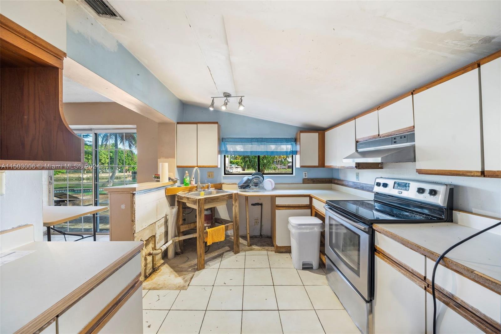 2702 Scott Street Hollywood, FL 33020 - Photo 26 of 42 a kitchen with a sink a counter top space a stove and cabinets