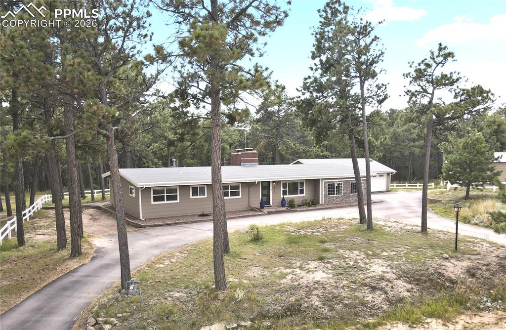 a view of a house with backyard and trees