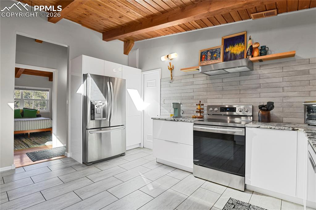 7015 McFerran Road Colorado Springs, CO 80908 - Photo 14 of 50 a kitchen with stainless steel appliances granite countertop a stove a refrigerator and a cabinets