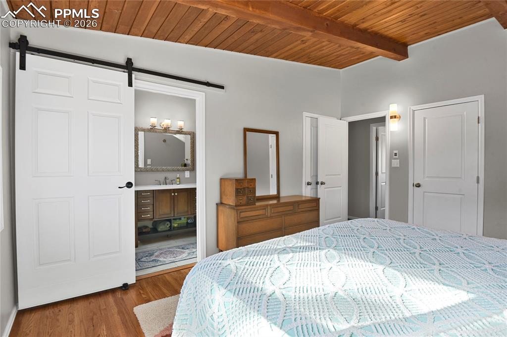 7015 McFerran Road Colorado Springs, CO 80908 - Photo 27 of 50 a large bedroom with a bed and a view of kitchen