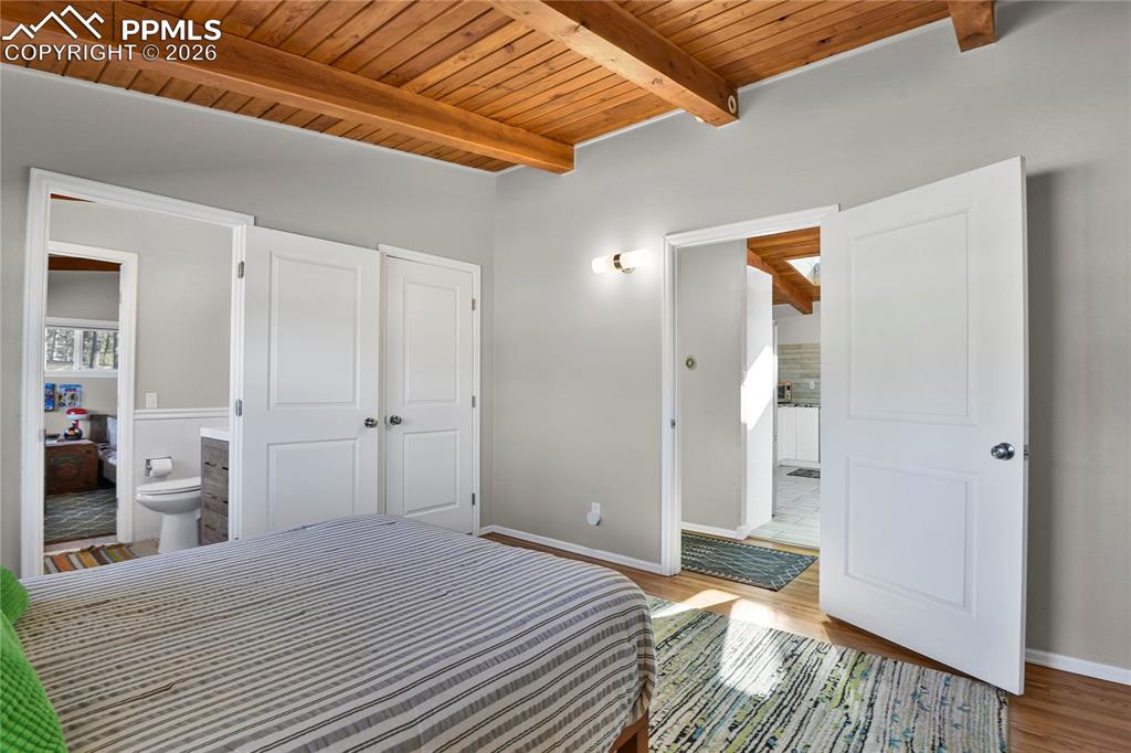 7015 McFerran Road Colorado Springs, CO 80908 - Photo 33 of 50 a bedroom with a bed and wooden floor