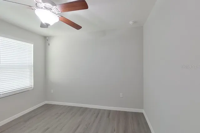 an empty room with a window and wooden floor