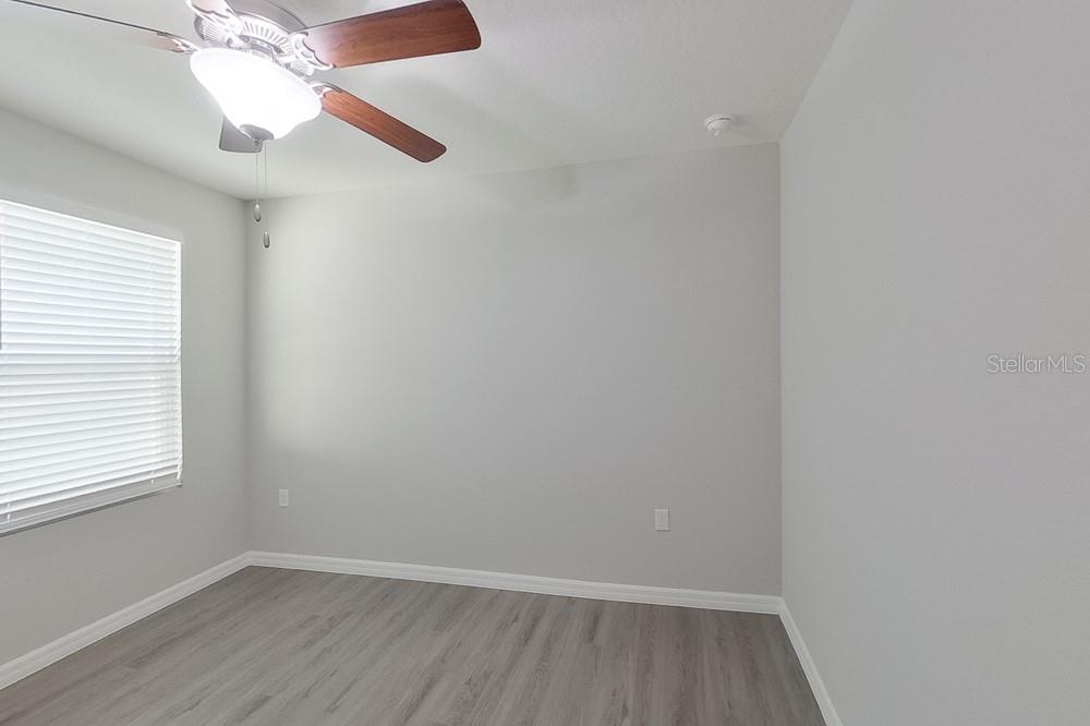 8731 Southwest 44th Court Ocala, FL 34476 - Photo 11 of 20 an empty room with a window and wooden floor