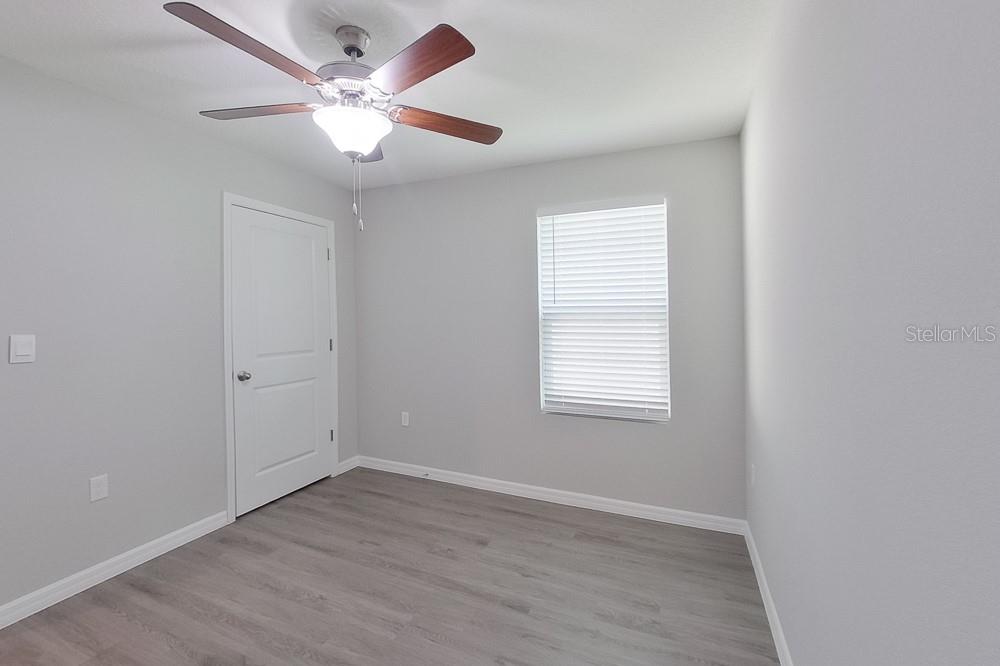 8731 Southwest 44th Court Ocala, FL 34476 - Photo 12 of 20 an empty room with wooden floor and windows