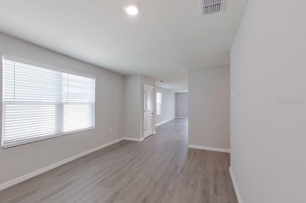 8731 Southwest 44th Court Ocala, FL 34476 - Photo 3 of 20 a view of an empty room with wooden floor and a window