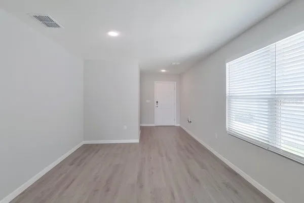 wooden floor in an empty room with a window