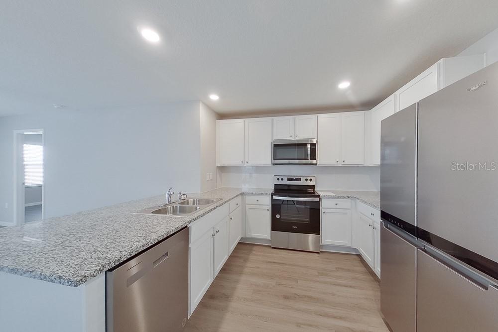 8731 Southwest 44th Court Ocala, FL 34476 - Photo 5 of 20 a kitchen with stainless steel appliances granite countertop a sink stove and refrigerator