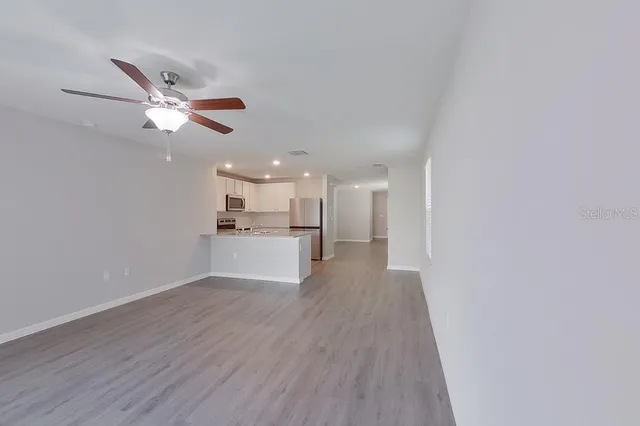 a view of a kitchen with a sink and wooden floor