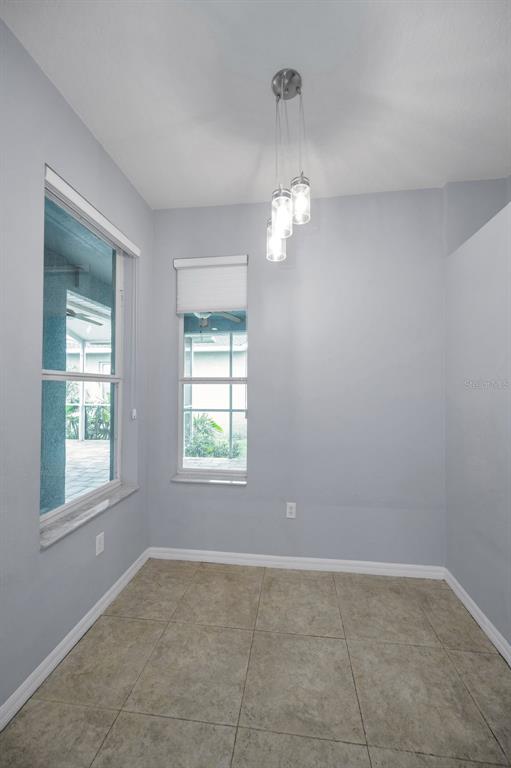 10125 Palladio Drive New Port Richey, FL 34655 - Photo 25 of 97 an empty room with chandelier fan and windows