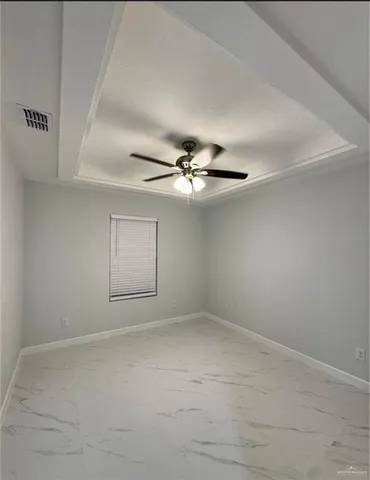 an empty room with a ceiling fan and a window