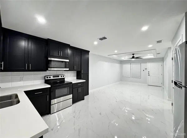 a kitchen with stainless steel appliances a refrigerator stove microwave and sink
