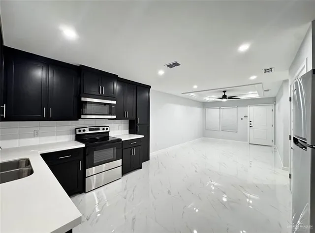 a kitchen with stainless steel appliances a refrigerator stove microwave and sink