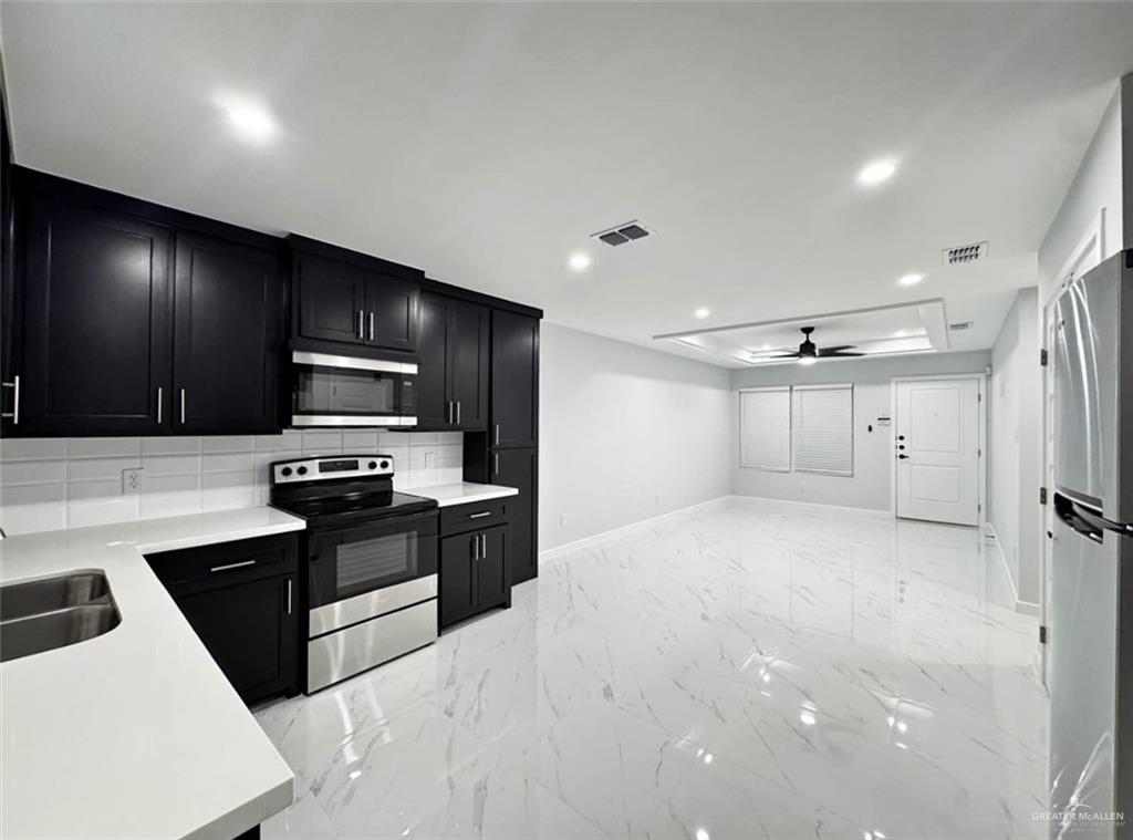 1604 Shadow Creek, Unit 1 Weslaco, TX 78596 - Photo 2 of 19 a kitchen with stainless steel appliances a refrigerator stove microwave and sink