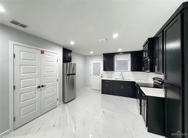 a large kitchen with a refrigerator and a sink