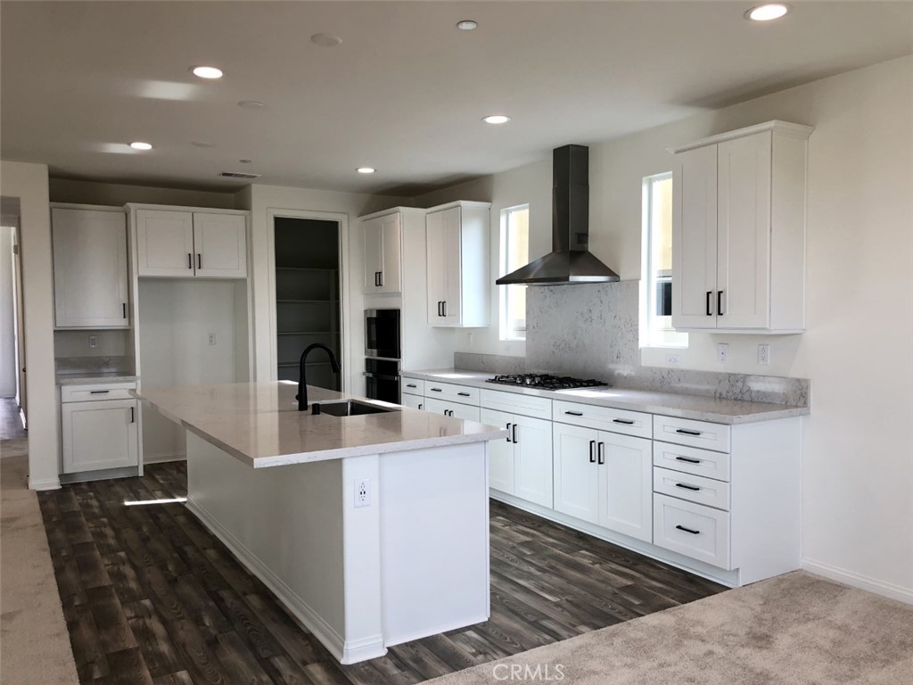 39547 Verbena Way Temecula, CA 92591 - Photo 11 of 21 a large kitchen with stainless steel appliances kitchen island granite countertop a sink and a refrigerator