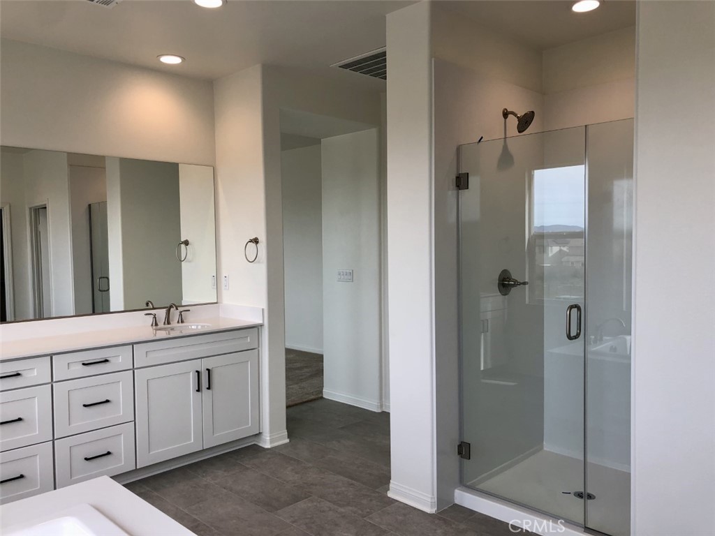 39547 Verbena Way Temecula, CA 92591 - Photo 15 of 21 a bathroom with a double vanity sink a large mirror and shower